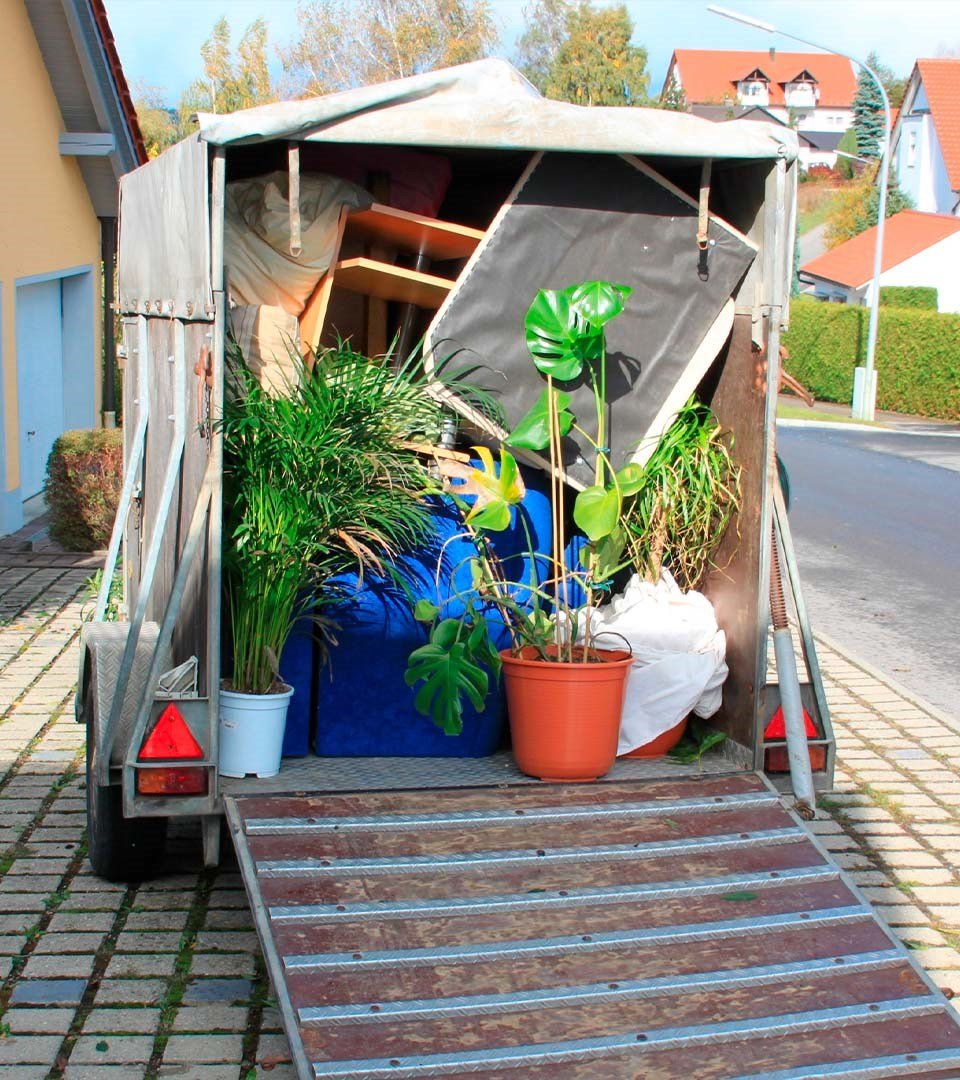 Photo de l'arrière d'une remorque fermée à l'extérieur. L'arrière est ouvert avec divers objets à l'intérieur, idéale pour le transport sécurisé.