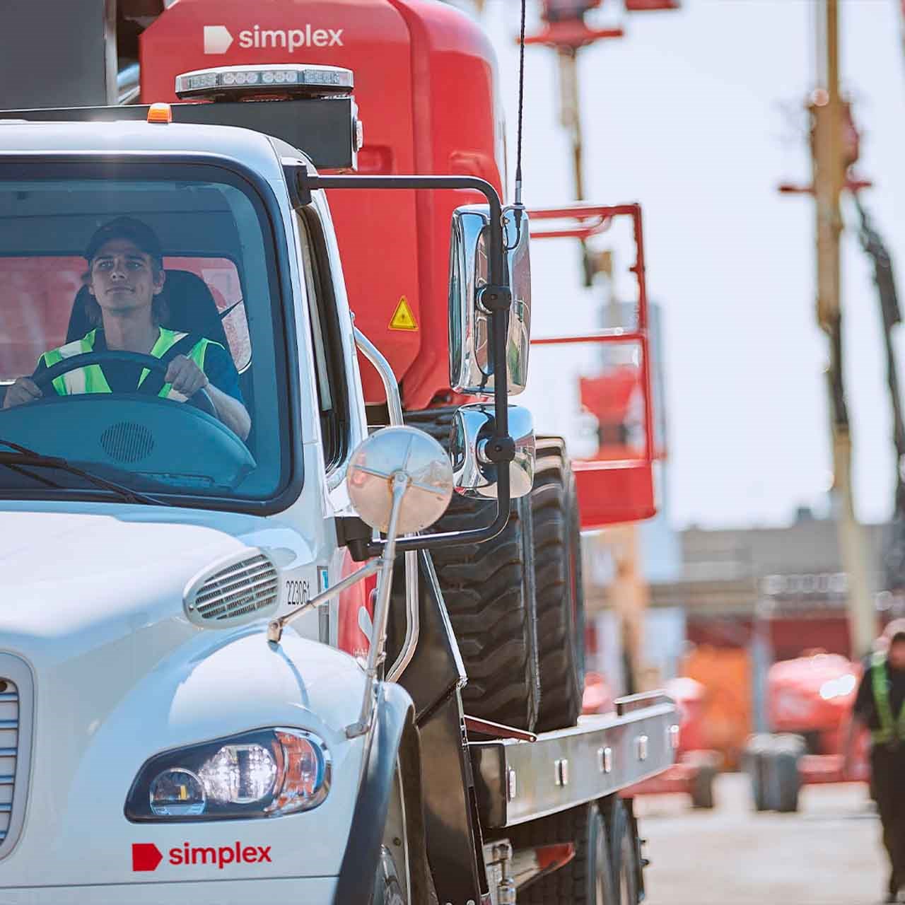 Camion de livraison Simplex transportant un équipement lourd sur plateau, illustrant la fiabilité et la rapidité du service de livraison.